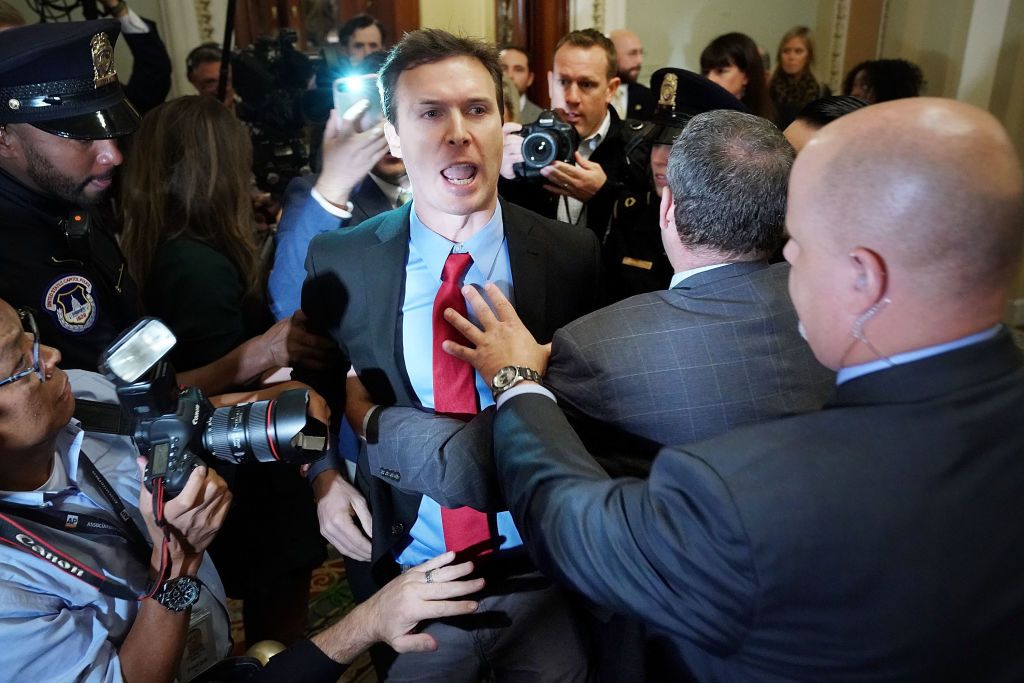 Activist Ryan Clayton is restrained by police after throwing Russian flags at President Trump.