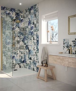 Deconstructed botanical tiles in shower area, with light wood sink unit and stool