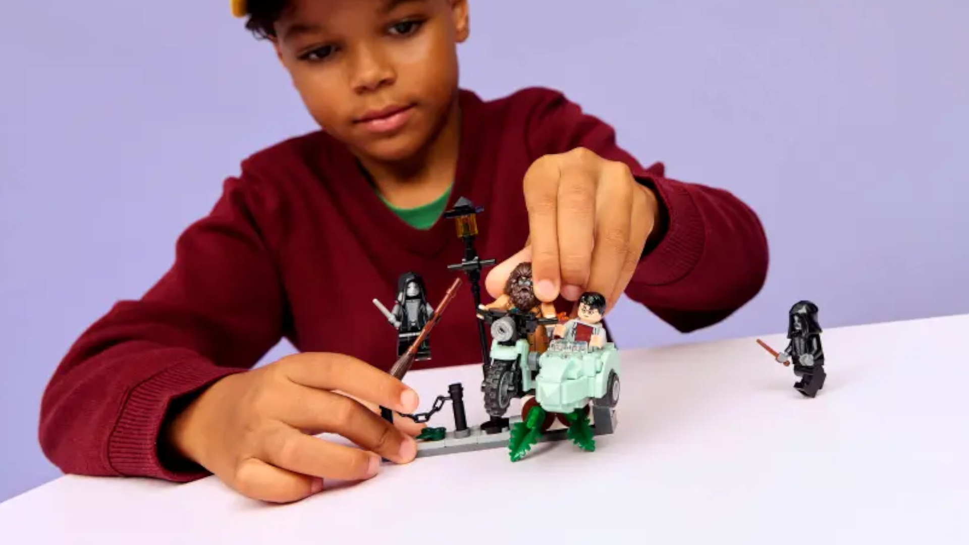 A child plays with minifigures in a motorbike and side car