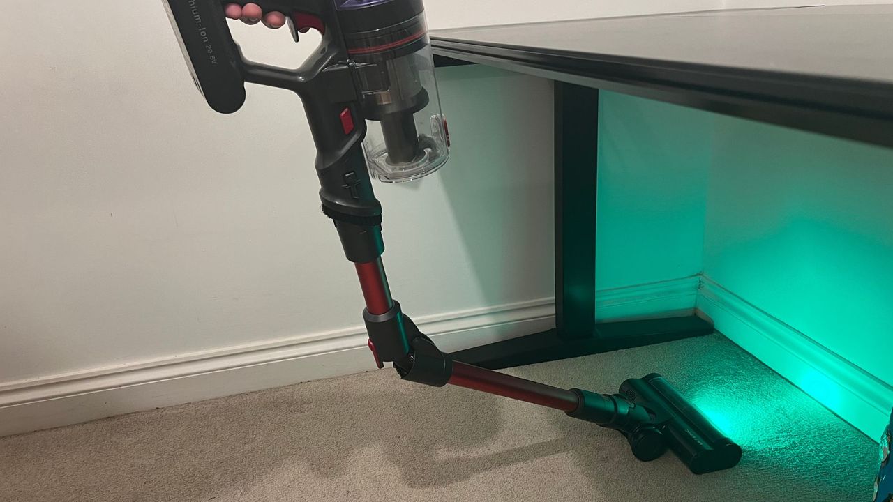 The Ultenic U16 Flex vacuum's bendable tube vacuuming under a table