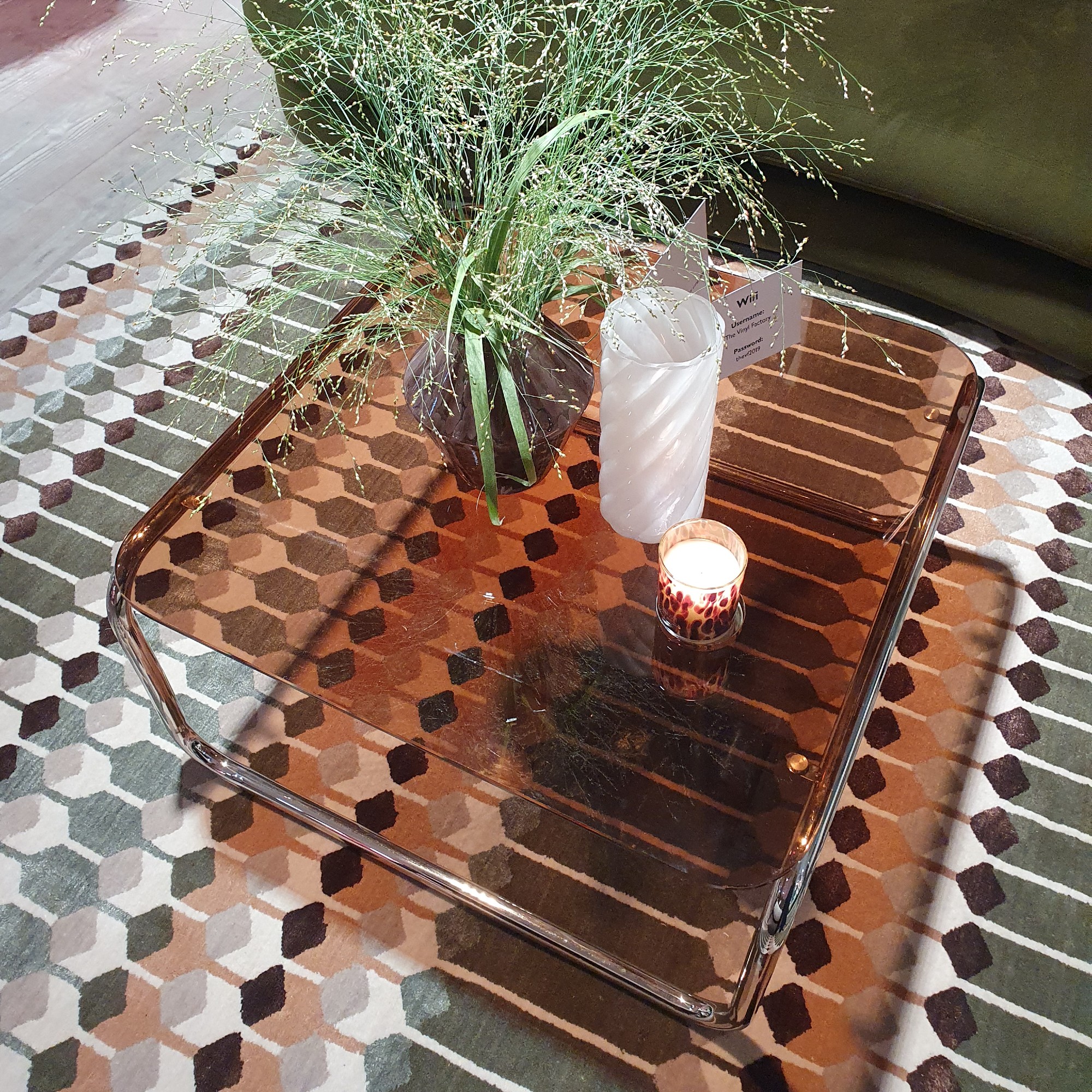 The John Lewis Retro amber glass coffee table on a patterned rug at the autumn/winter 2025 press preview