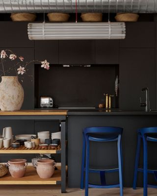 colors that go with black, with a black painted kitchen juxtaposed with deep blue chairs