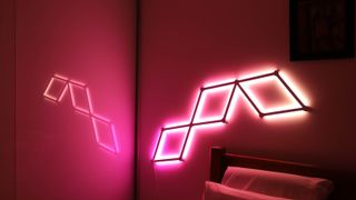 Nanoleaf Lines attached to a wall and illuminating in red and orange hues