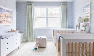 Nursery ideas in pale pastel blue, with pastel green drapes, white furniture and twin cots.