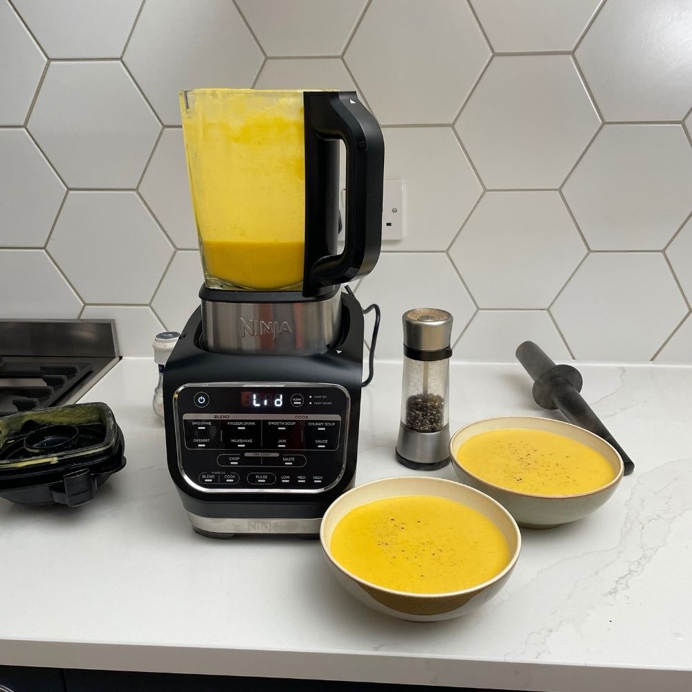 Ninja Foodi HB150UK Blender and Soup Maker next to bowls of butternut soup