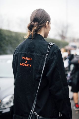 American Model Vanessa Moody wears her hair in a low loose bun and wears a black Alexander Wang "Wang x Moody" black denim jacket after the Bottega Veneta show during the Milan Fashion Week Fall/Winter 2016/17 on February 27, 2016 in Milan, Italy.