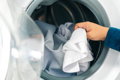 Person removing clothes from a tumble dryer
