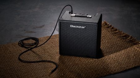 Blackstar Debut Bass 25: this compact little combo is finished in black with matching grille clothe and is photographed in close-up against a stone floor and weaved rug.