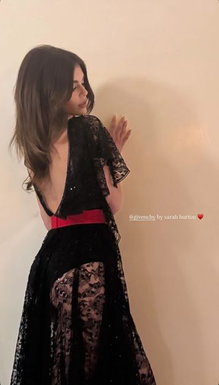 A photo of Kaia Gerber modeling a Givenchy black lace dress designed by creative director Sarah Burton.