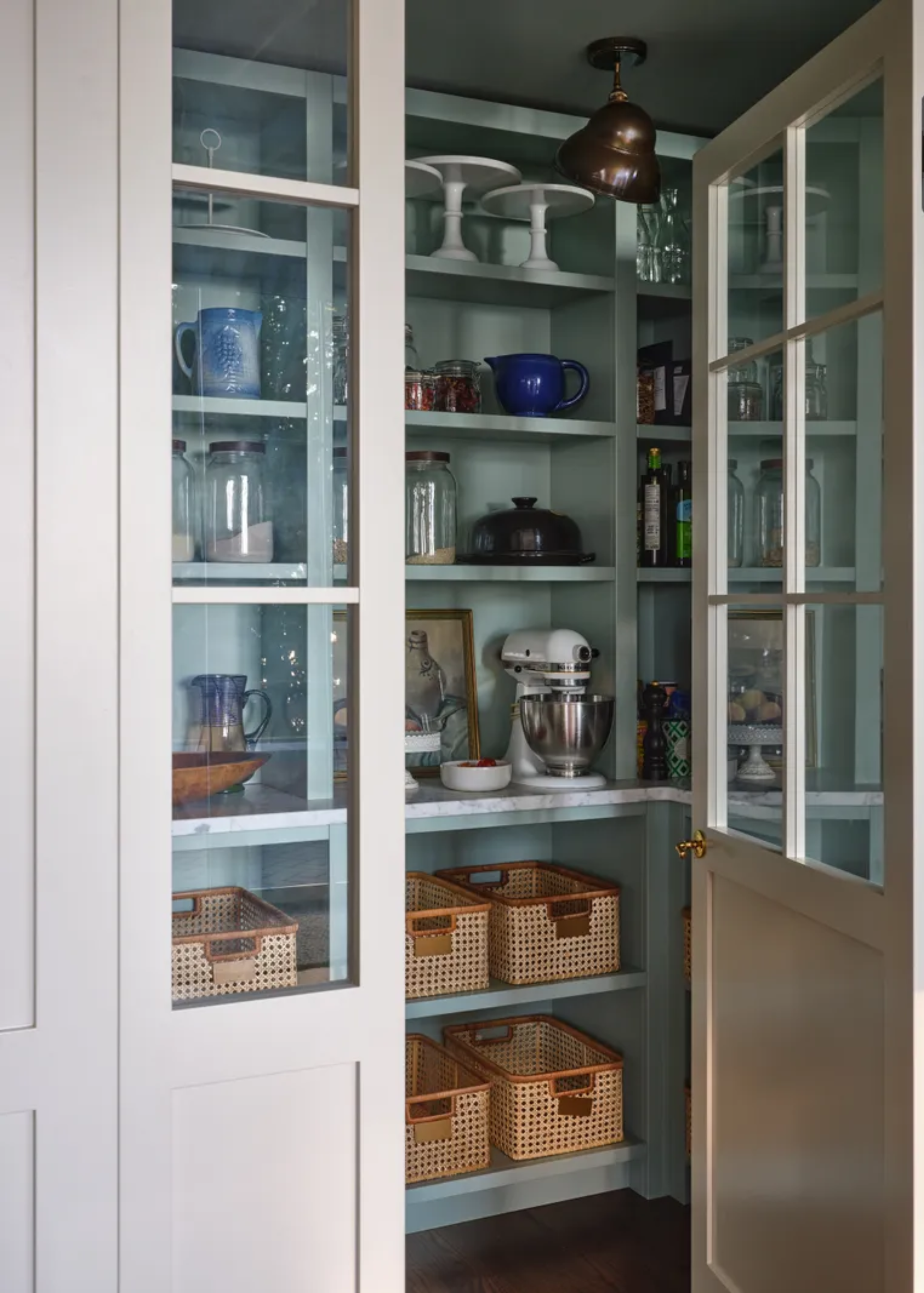 A kitchen pantry with rattan-style baskets and cooking appliances