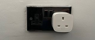D-Link Mini Wi-Fi Smart Plug DSP-W118 plugged into a silver power outlet