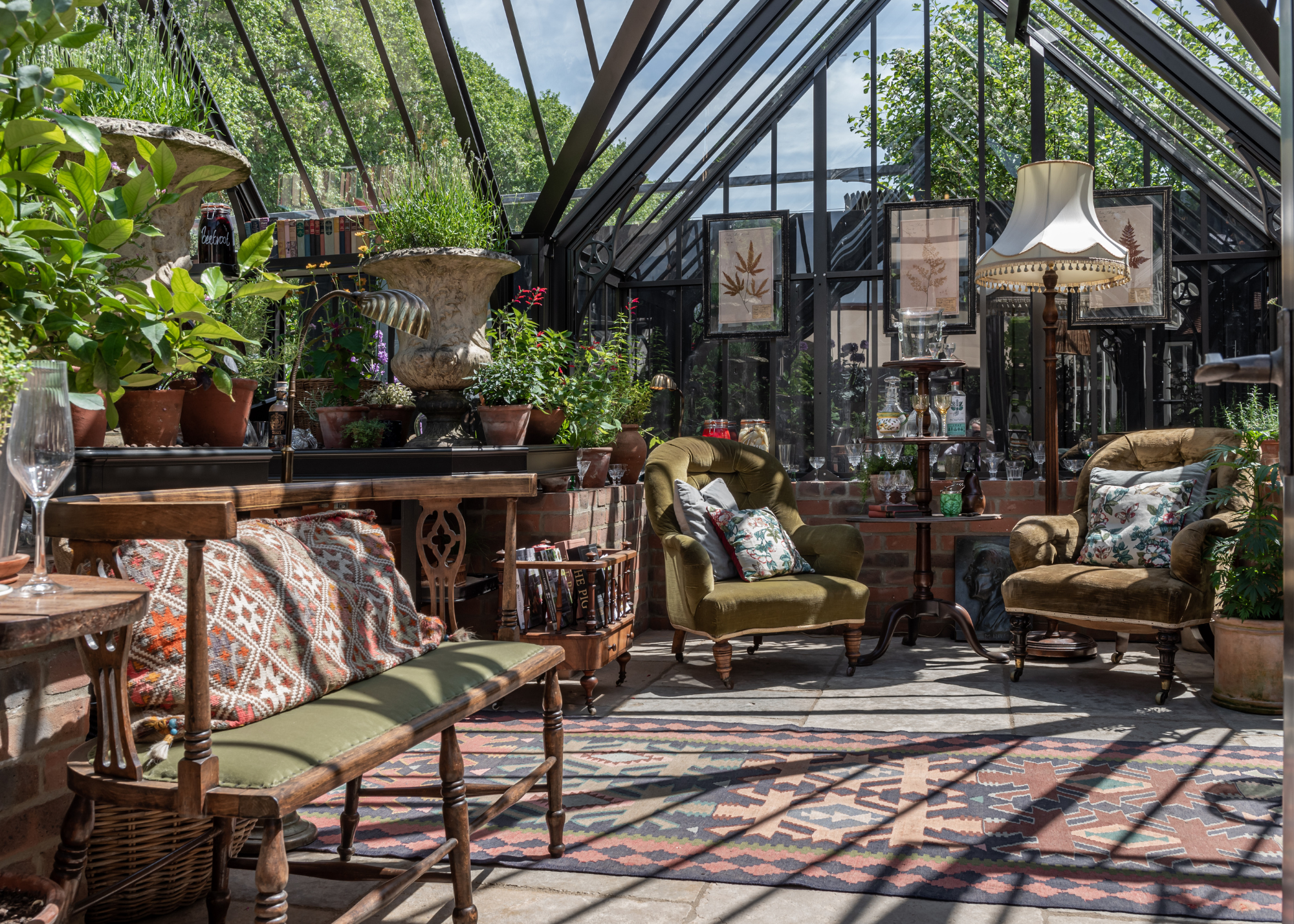 greenhouse furnished with traditional living room furniture and paintings