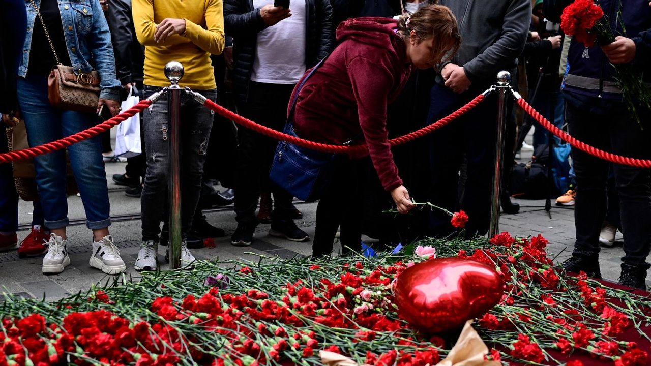 People lay flowers at a makeshift memorial