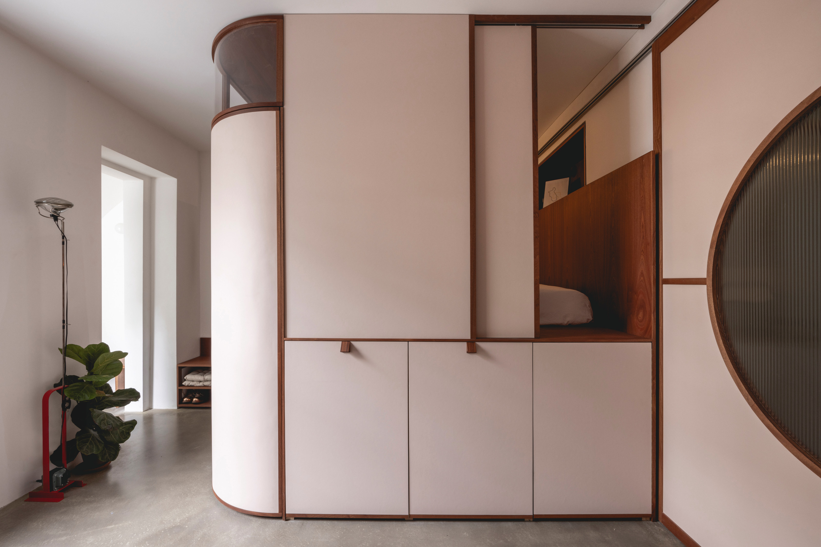 Bed built in to joinery with curved edges and moving walls