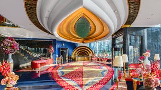 Internal shot of Jumeirah Burj Al Arab lobby with blue and gold floor, gold ceiling, red furniture and blue walls