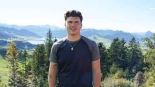 Harry Clark standing against an alpine backdrop in Pilgrimage: The Road Through the Alps