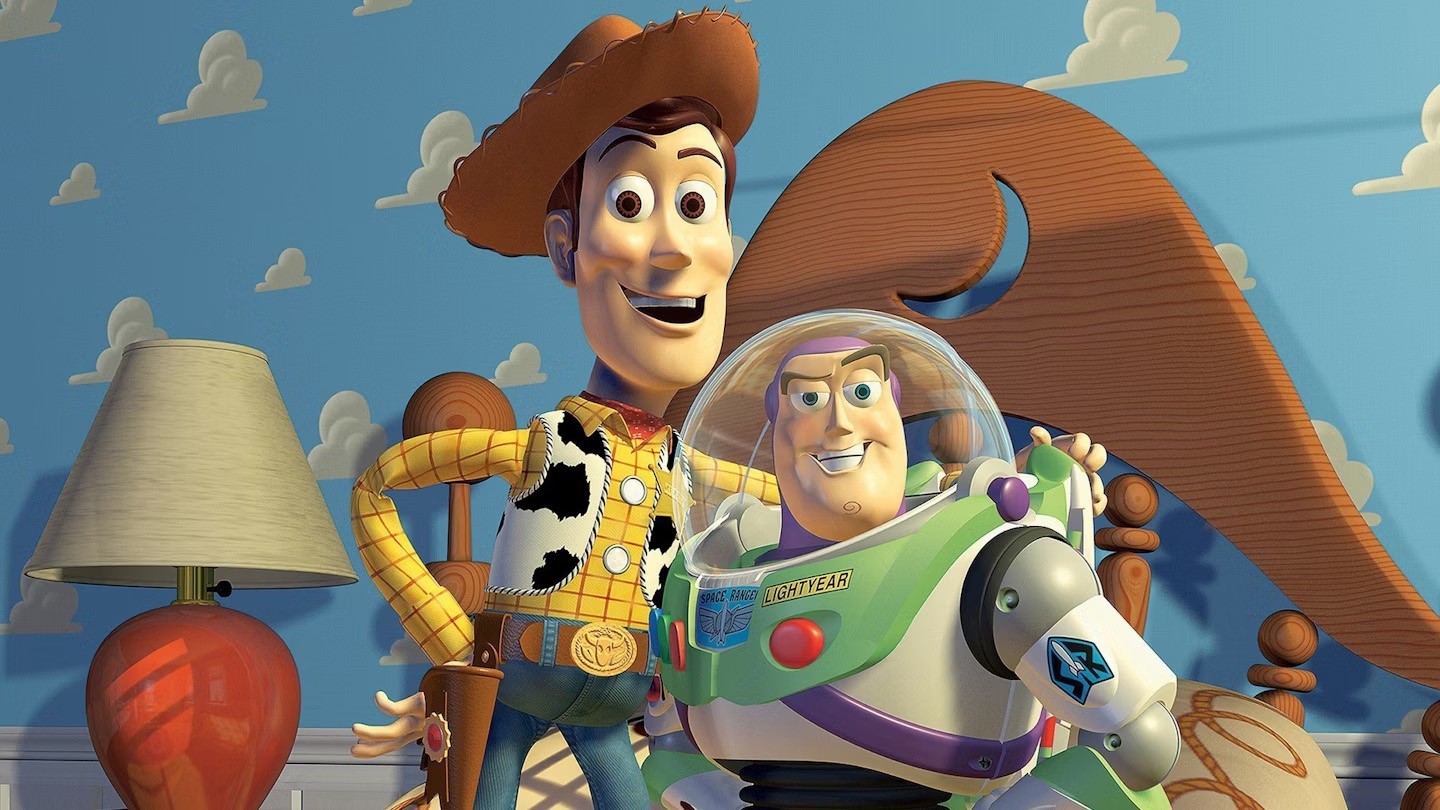 Pixar vs DreamWorks; a blue monster and a green monster on a stage, a cowboy and a space man toys