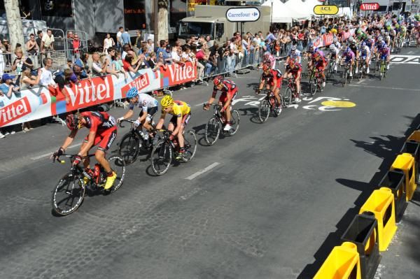 Cadel Evans is led by his BMC team on the Champs-Elysees.