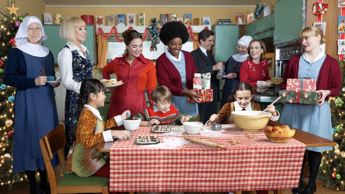 The cast of Call the Midwife stand around a table as the Turner children bake in the Call the Midwife Christmas special 2024.