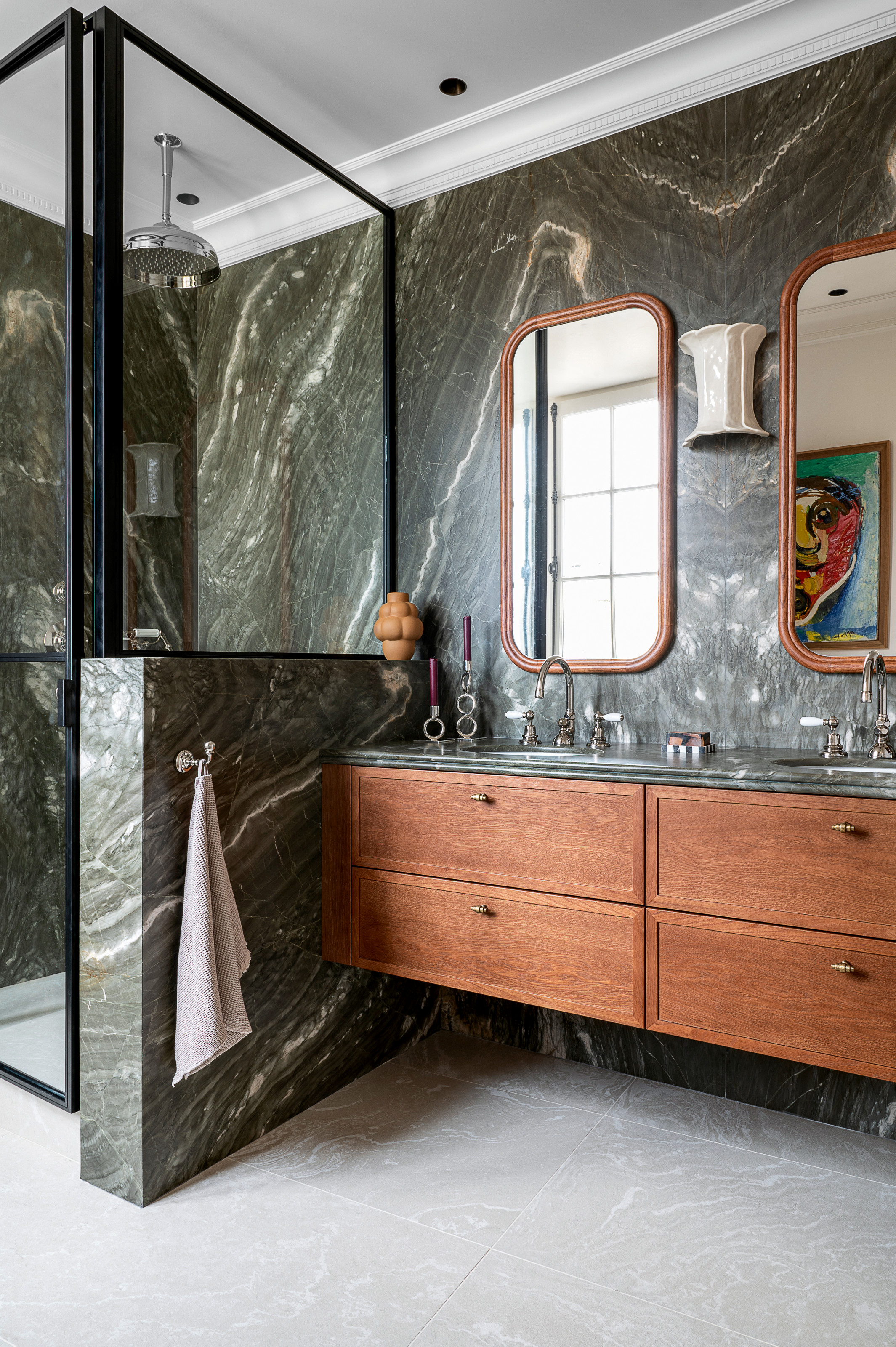 Bathroom with dark green marble and rich wood double vanity