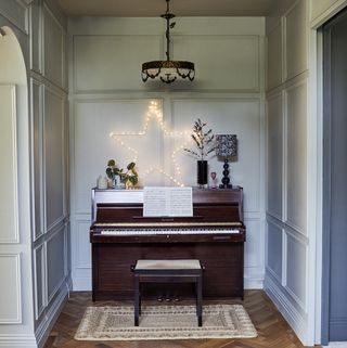 Entrance hallway with upright piano, decorative star light and rug