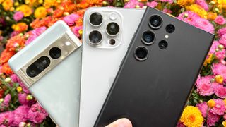 Google Pixel 7 Pro, iPhone 15 Pro Max and Galaxy S23 Ultra camera shown held in one hand