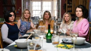 From left to right: Sarah Greene, Anne-Marie Duff, Sharon Horgan, Eva Birthistle and Eve Hewson sitting around a table with wine glasses on it in Bad Sisters.