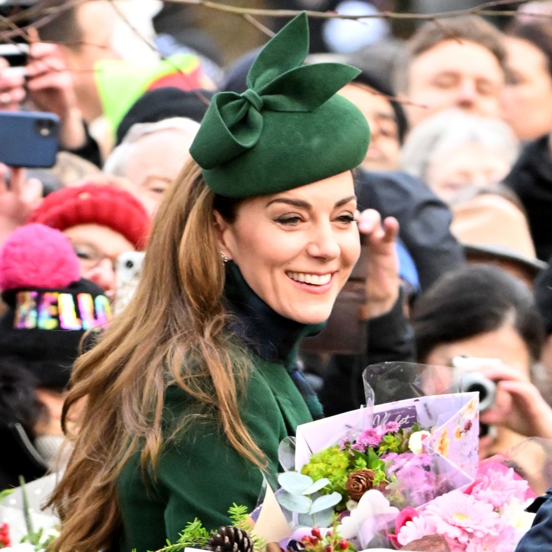 Kate Middleton wears a green hat and coat as she&#039;s surrounded by royal fans who have given her bunches of flowers at Sandringham