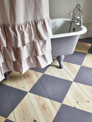 Bathroom with large scale harlequin painted pattern on floorboards