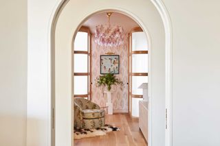 a pink sitting room viewed through an arch