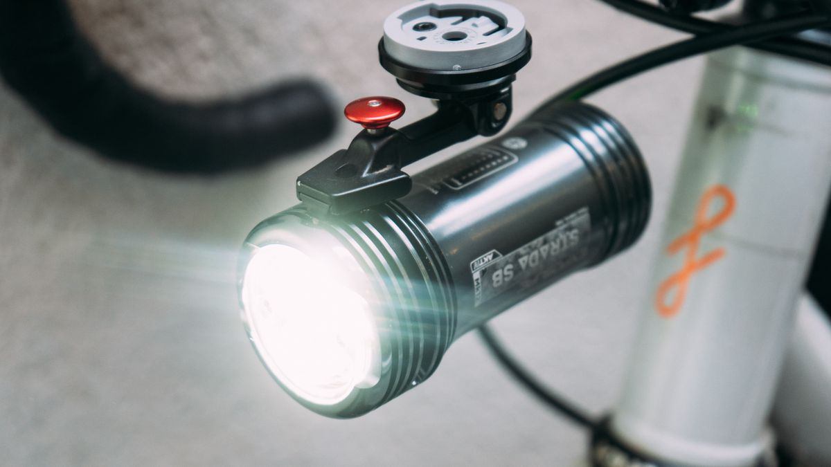 A close up of a bright front bike light, switched on