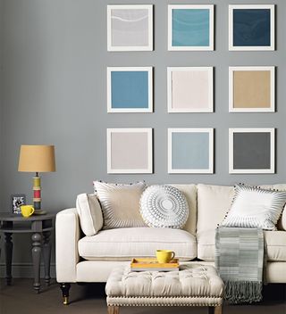 grey living room with white sofa and coloured picture gallery