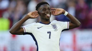 Bukayo Saka celebrates scoring England's third shootout penalty against Switzerland at Euro 2024.