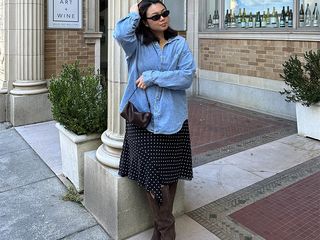 Marina wars oversize denim shirt, polka dot skirt, and suede boots.