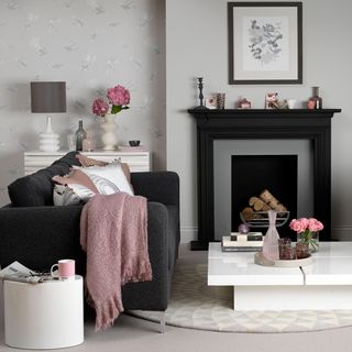 Modern grey living room ideas with black sofa and pink cushions and throw