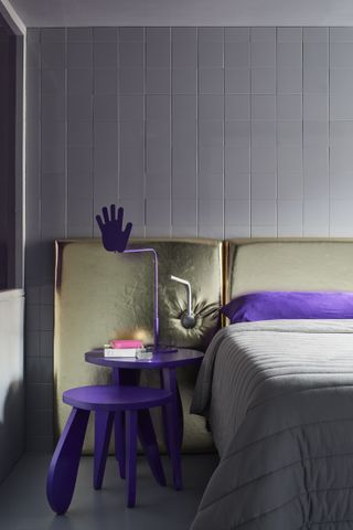 A bedroom with a gold and purple scheme