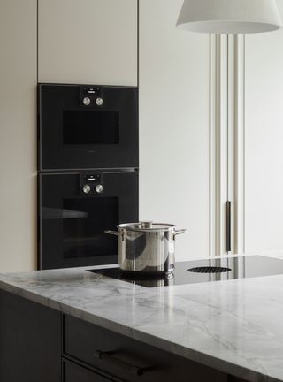 a gaggenau oven duo in a modern kitchen with a pot on an induction hob