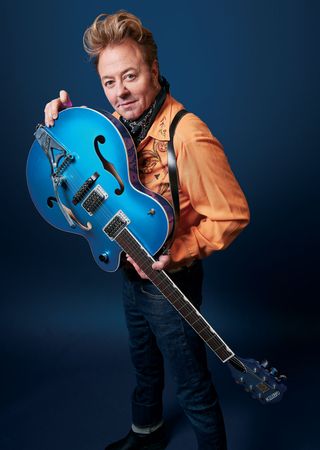 Brian Setzer poses with a Gretsch electric guitar