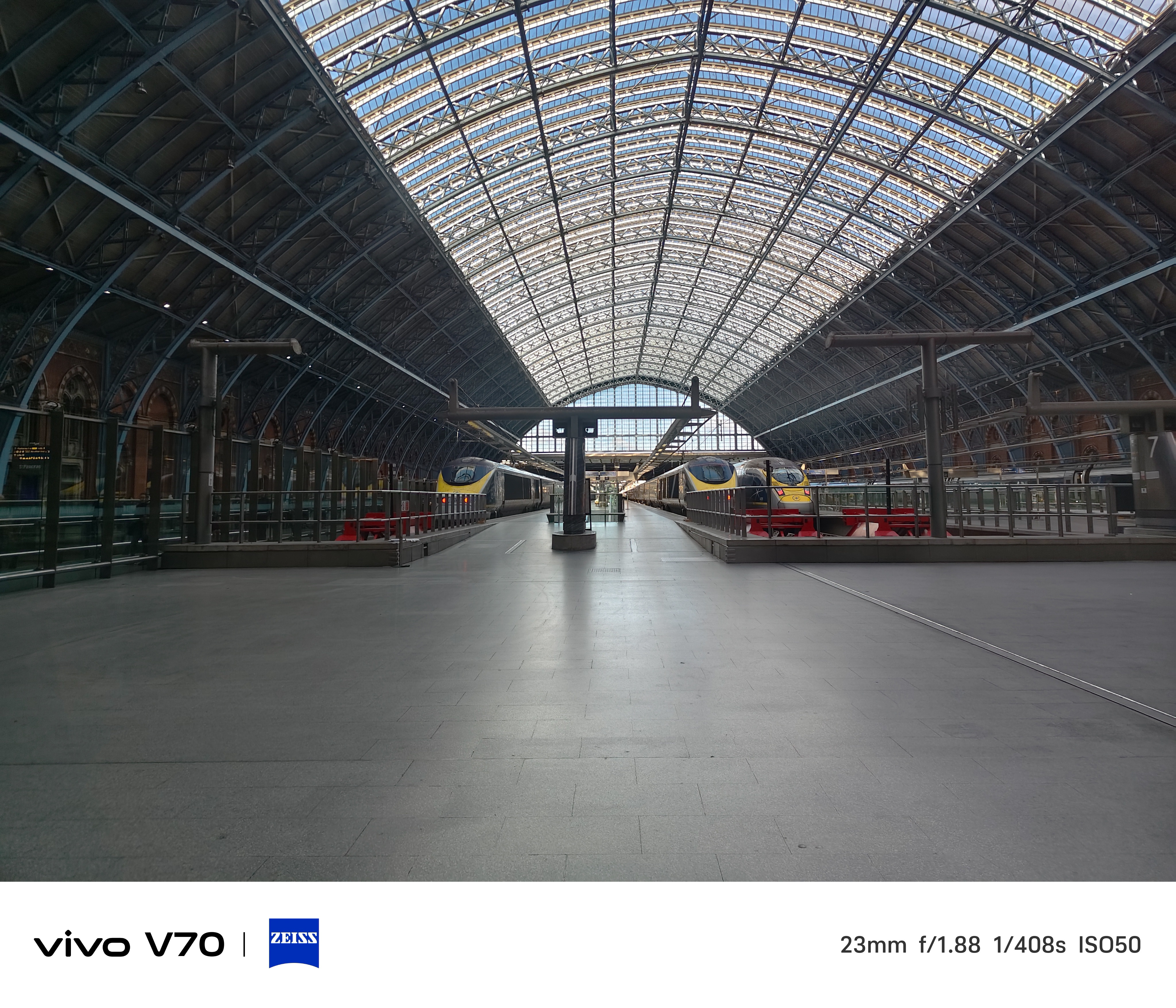 Interior wide shot of St Pancras International station with Eurostar trains beneath the arched glass roof.
