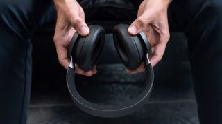 Best headphone sound: male hands holding generic headphones