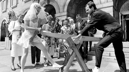 A German couple engaged in the traditional log-cutting event