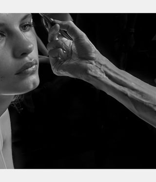 black and white image of hand reaching for woman's face, by Larry Fink