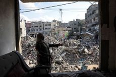 A Palestinian woman gestures as she explains how her home was destroyed duing the Israeli bombardment, in Bureij in the central of Gaza Strip