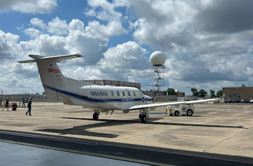 a small white airplane on a concrete slab.