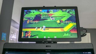 A screenshot of Yoshi's Crafted World running on a portable monitor mounted above the Peloton Bike Plus