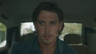 Austin Butler sitting in the back of a car in Caught Stealing.