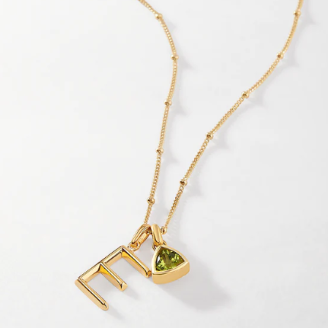 ethical jewellery: gold beaded necklace with E initial and peridot birthstone