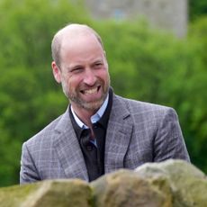 Prince William in a gray blazer smiling at farmers