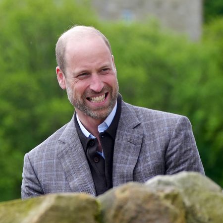 Prince William in a gray blazer smiling at farmers