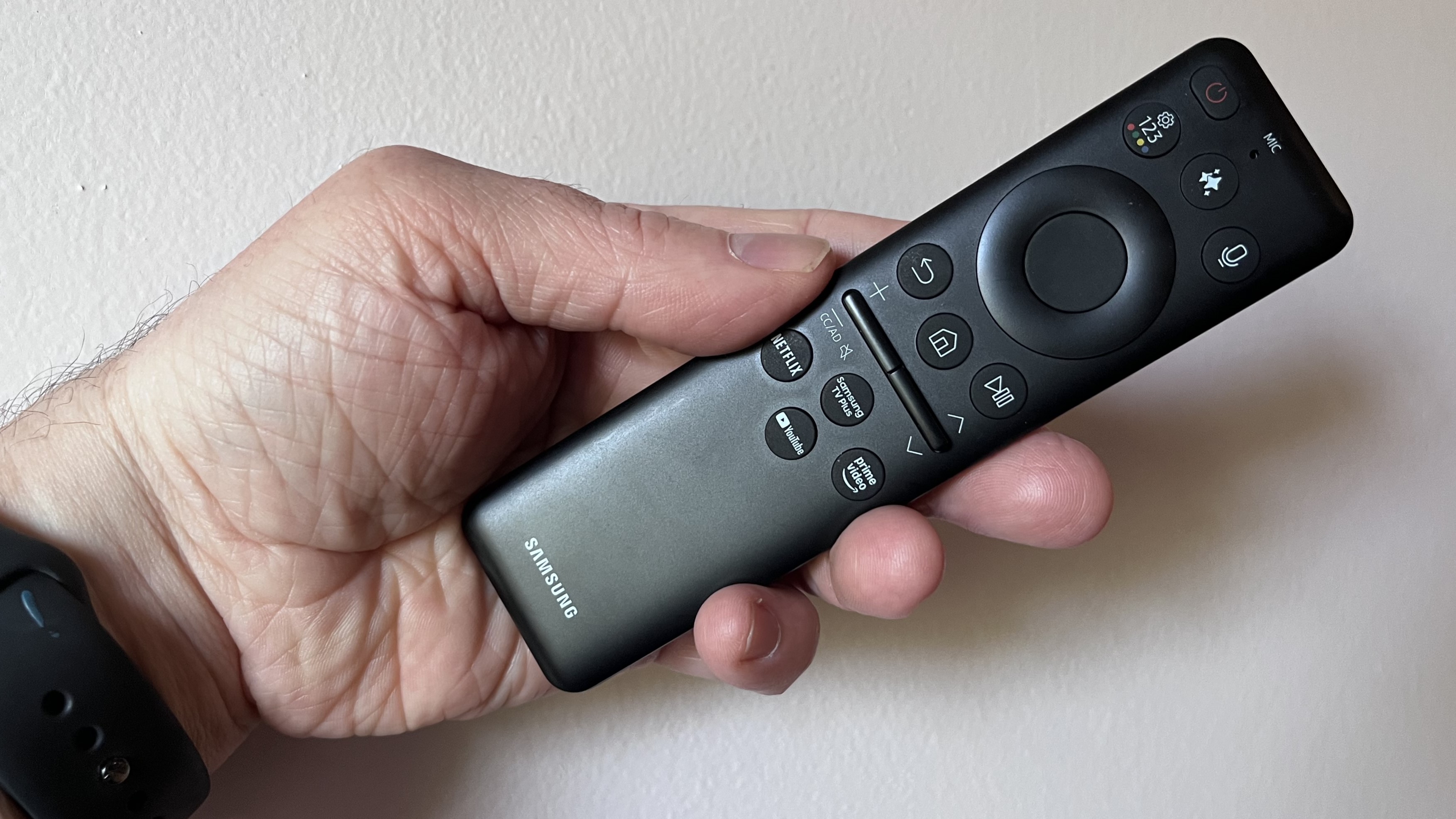 Samsung QN90F SolarCell remote held in hand